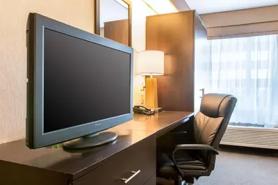 a computer monitor sitting on a desk with a chair at Sleep Inn & Suites Oregon - Toledo in Oregon