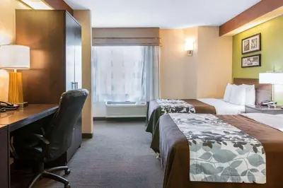 a hotel room with two beds and a desk at Sleep Inn & Suites Oregon - Toledo in Oregon