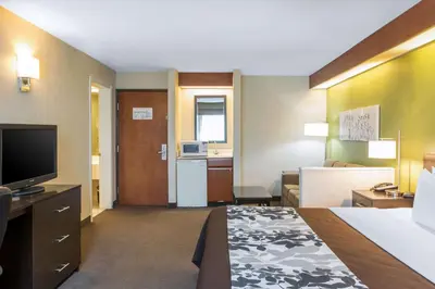 a hotel room with a bed and a flat screen tv at Sleep Inn & Suites Oregon - Toledo in Oregon