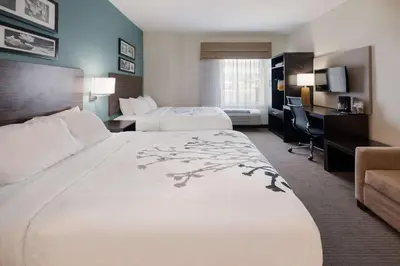 a hotel room with two beds and a desk at Sleep Inn & Suites Port Clinton in Port Clinton