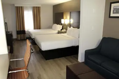 a hotel room with two beds and a couch at Comfort Suites Miamisburg - Dayton South in Miamisburg