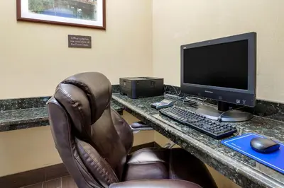 a desk with a computer monitor and a keyboard and mouse at Comfort Suites Miamisburg - Dayton South in Miamisburg