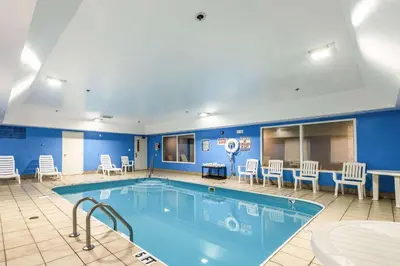a pool in a hotel room with chairs and tables at Comfort Inn & Suites Dayton Northwest - Englewood in Dayton