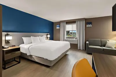 a hotel room with a large bed and a chair at Comfort Inn & Suites Fremont in Fremont