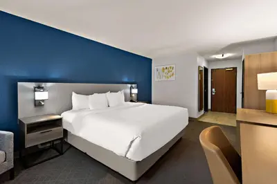 a bedroom with a large white bed and a blue wall at Comfort Inn & Suites Fremont in Fremont