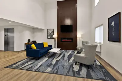 a living room with two chairs and a blue couch at Comfort Inn & Suites Fremont in Fremont
