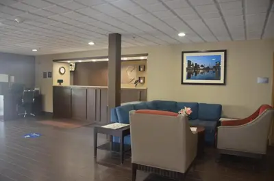 a waiting room with a blue couch and a table at Comfort Inn & Suites Maumee - Toledo I80-90 in Maumee