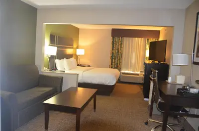 a hotel room with a bed and a couch at Comfort Inn & Suites Maumee - Toledo I80-90 in Maumee