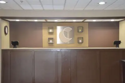 a reception counter in a room with a sign on the wall at Comfort Inn & Suites Maumee - Toledo I80-90 in Maumee