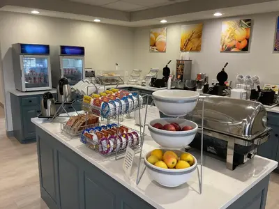 a kitchen with a counter with bowls of fruit on it at Comfort Suites Hotel and Conference Center in Berlin