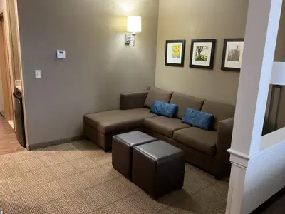 a living room with a couch and blue pillows at Comfort Suites Hotel and Conference Center in Berlin