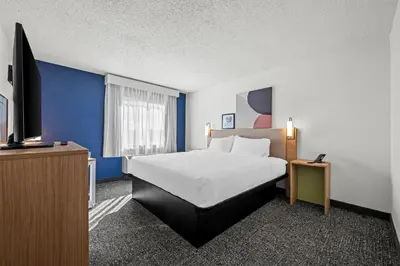 a hotel room with a bed and a flat screen tv at Spark By Hilton Cleveland Beachwood in Beachwood