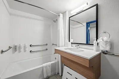 a bathroom with a sink and a tub and a mirror at Spark By Hilton Cleveland Beachwood in Beachwood