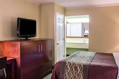 a bedroom with a bed and a flat screen tv at Days Inn by Wyndham Austintown in Austintown