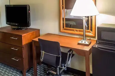 a desk with a television and a lamp and a chair at Days Inn by Wyndham Austintown in Austintown