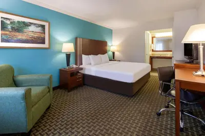 a hotel room with a bed and a chair and a desk at Days Inn by Wyndham Austintown in Austintown
