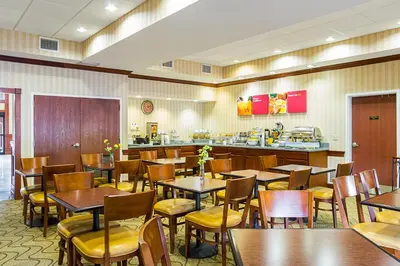 a restaurant with tables and chairs and a counter at Comfort Suites Twinsburg in Twinsburg