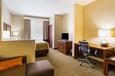 a hotel room with a bed and a desk with a computer at Comfort Suites Twinsburg in Twinsburg