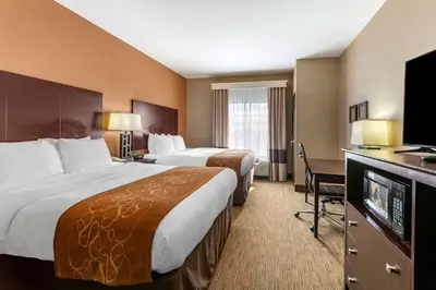 a hotel room with two beds and a flat screen tv at Comfort Suites Perrysburg - Toledo South in Perrysburg