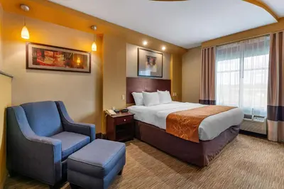 a hotel room with a bed and a chair at Comfort Suites Perrysburg - Toledo South in Perrysburg