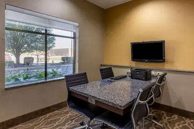a conference room with a table with chairs and a television at Comfort Suites Perrysburg - Toledo South in Perrysburg