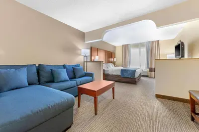 a living room with a blue couch in a hotel room at Comfort Suites Findlay I-75 near Sports Complex in Findlay
