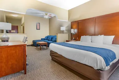 a hotel room with a large bed and a chair at Comfort Suites Findlay I-75 near Sports Complex in Findlay