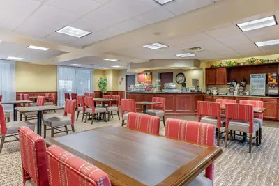 a dining room with tables and chairs and a counter at Comfort Suites Findlay I-75 near Sports Complex in Findlay