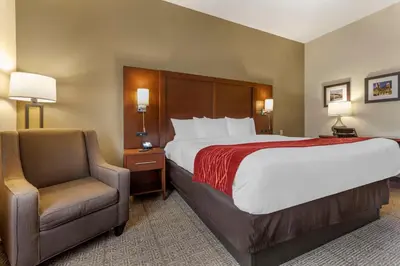 a hotel room with a bed and a chair at Comfort Inn & Suites Streetsboro - Kent in Streetsboro
