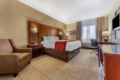 a large hotel room with a bed and a chair at Comfort Inn & Suites Streetsboro - Kent in Streetsboro