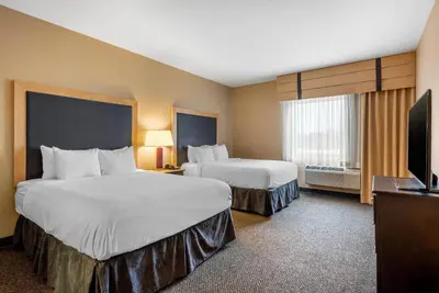 a hotel room with two beds and a flat screen tv at Cambria Hotel Akron - Canton Airport in Uniontown