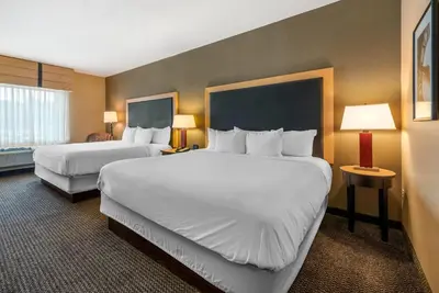 a hotel room with two beds and two lamps at Cambria Hotel Akron - Canton Airport in Uniontown