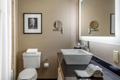a bathroom with a white toilet and a sink at Cambria Hotel Akron - Canton Airport in Uniontown