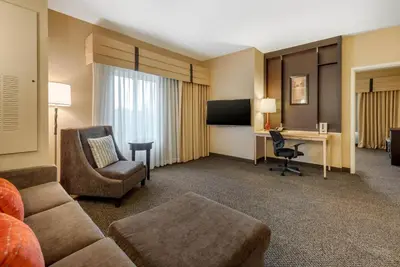 a hotel room with a couch and a desk at Cambria Hotel Akron - Canton Airport in Uniontown