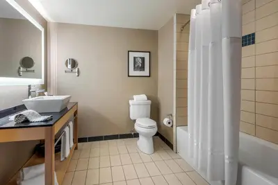a bathroom with a toilet and a sink and a shower at Cambria Hotel Akron - Canton Airport in Uniontown