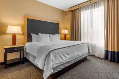 a hotel room with a large bed and a window at Cambria Hotel Akron - Canton Airport in Uniontown