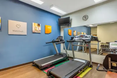 a gym with a treadmill and a tv in a room at Comfort Suites South Point - Huntington in Burlington
