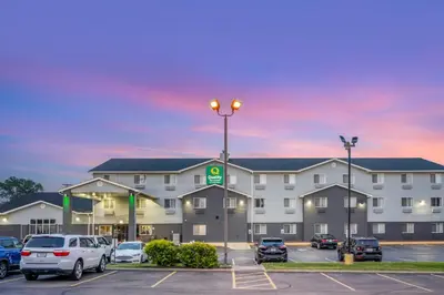 a large building with cars parked in a parking lot at Quality Inn & Suites Delaware South in Delaware