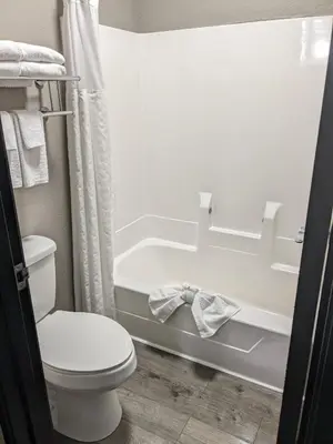 a bathroom with a toilet and a bath tub at Quality Inn & Suites Delaware South in Delaware