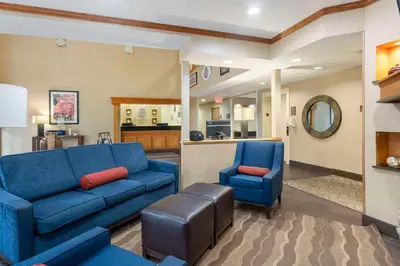 a living room with a blue couch and two chairs at Comfort Inn North-Polaris in Columbus
