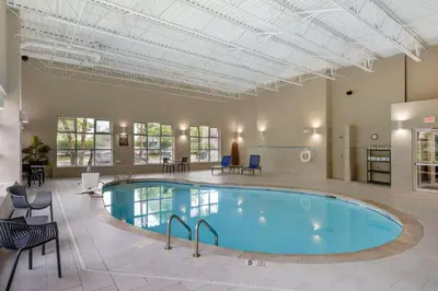 a pool in a large room with chairs and a table at Comfort Inn North-Polaris in Columbus