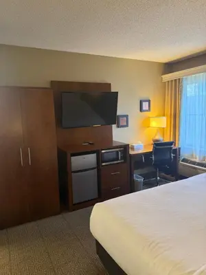 a hotel room with a bed and a flat screen tv at Comfort Inn North-Polaris in Columbus