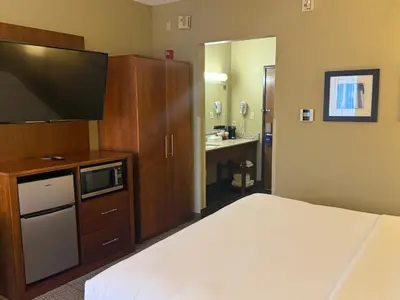 a bedroom with a bed and a bathroom with a sink at Comfort Inn North-Polaris in Columbus