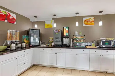 a kitchen with white cabinets and a counter at Quality Inn Wooster in Wooster