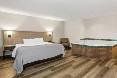 a hotel room with a bed and a bathtub at Quality Inn East Liverpool - Calcutta in East Liverpool