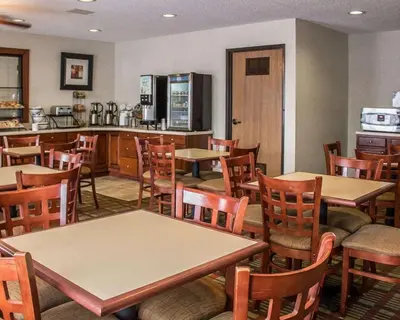 a restaurant with tables and chairs and a kitchen at Quality Inn East Liverpool - Calcutta in East Liverpool