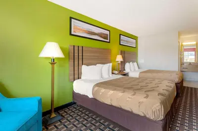 a hotel room with two beds and a blue couch at Quality Inn - Huron, Sandusky OH in Huron