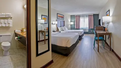 a hotel room with a bed and a desk with a toilet at Quality Inn Milan-Sandusky in Milan