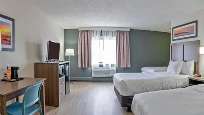 a hotel room with two beds and a desk at Quality Inn Milan-Sandusky in Milan
