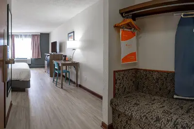 a hotel room with a bed and a desk with a table at Quality Inn Milan-Sandusky in Milan